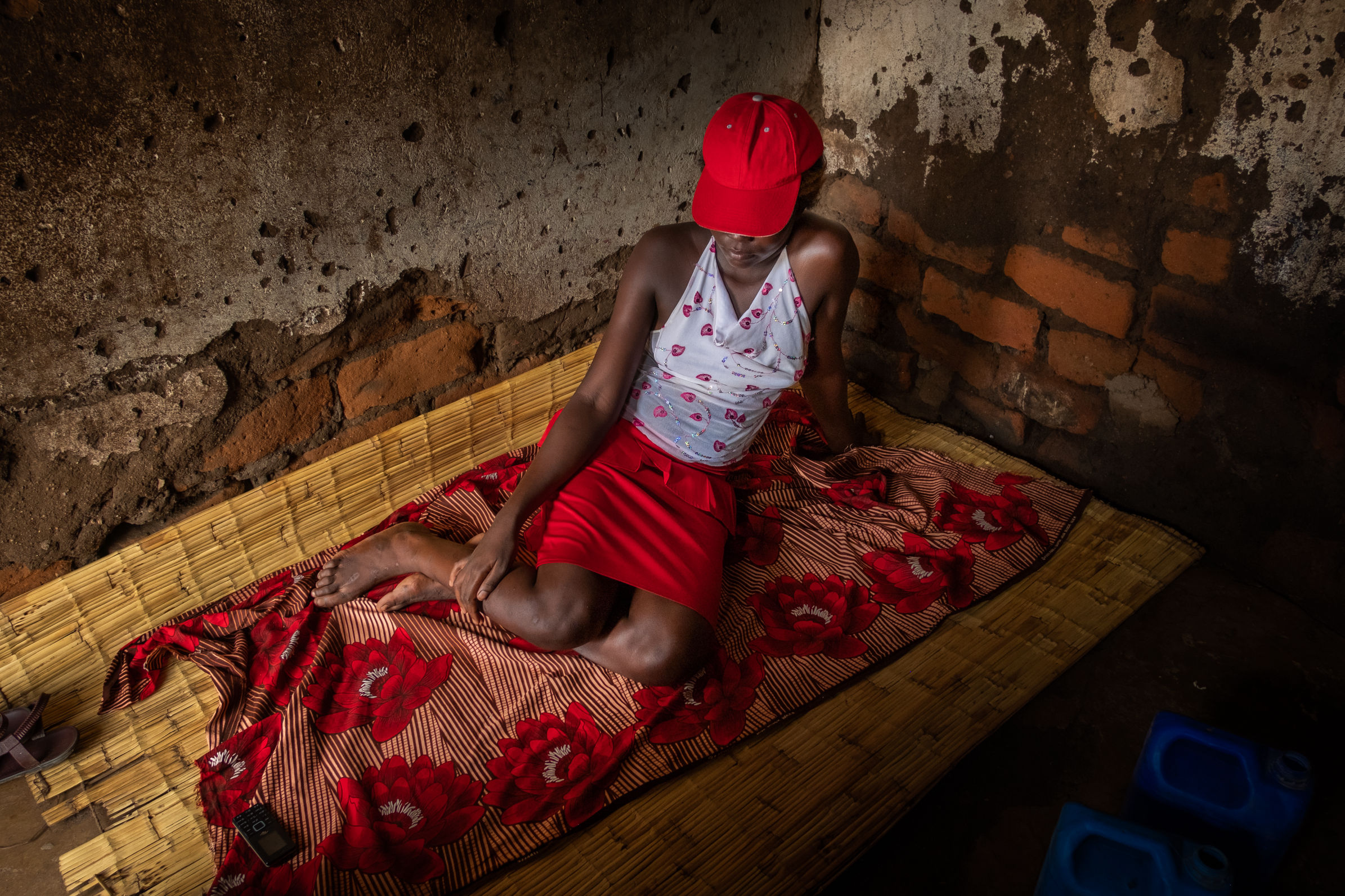 A sex worker on grass mat in a rented room where she lives that is also used for clients in a compound in Nsanje, Malawi. Photo by Isabel Corthier/MSF.