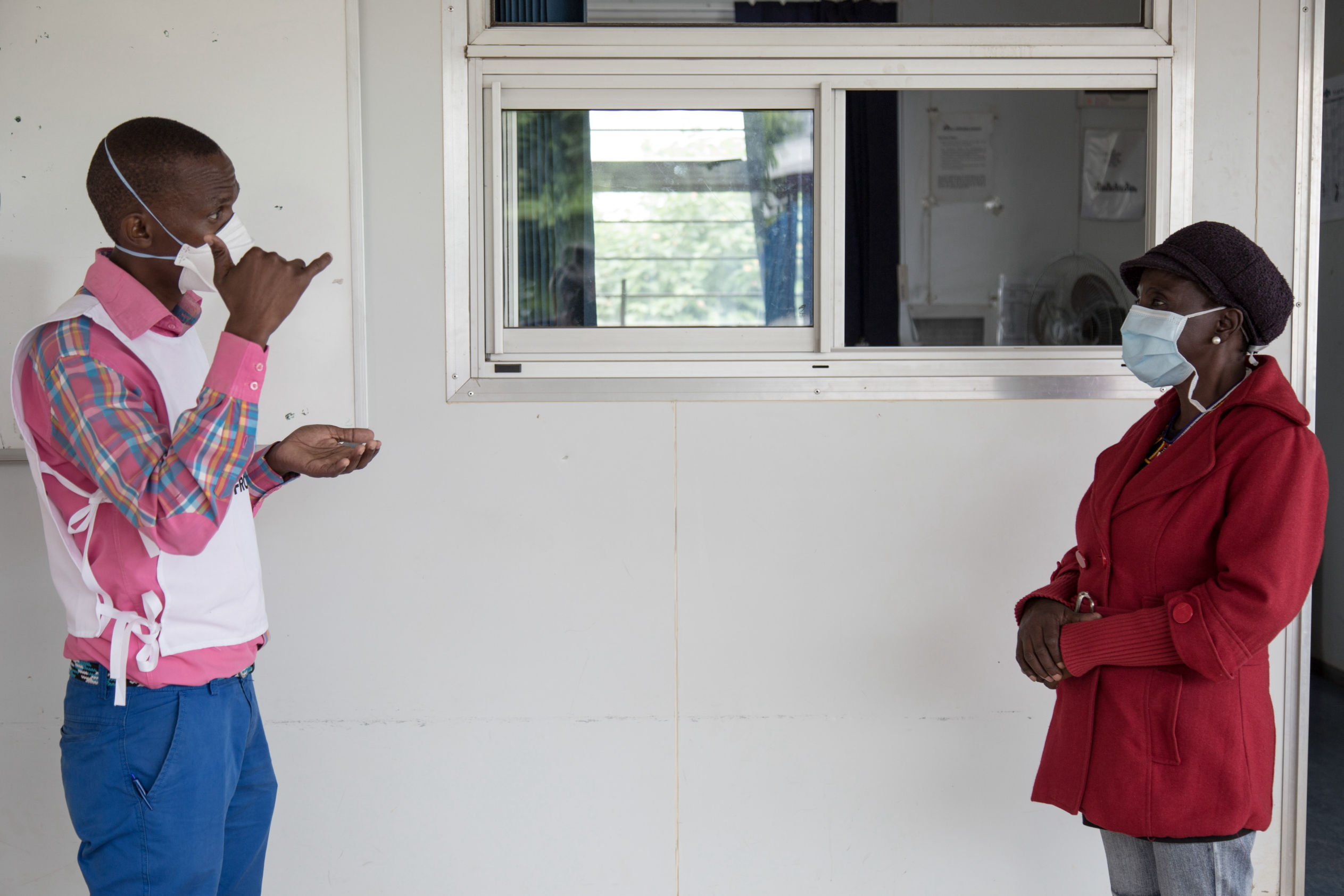Celumusa Hlatswako (à gauche), conseiller mobile de MSF, parle en langage des signes avec Thulie (à droite), une patiente atteinte de MDR-TB non sourde, lors d'une formation en langage gestuel. Thulie est guérie mais elle voulait apprendre la langue des signes pour aider d'autres patients et d'autres personnes sourdes dans sa communauté. Clinique Matsapha, région de Manzini, Swaziland (Eswatini). Photo : Alexis Huguet.