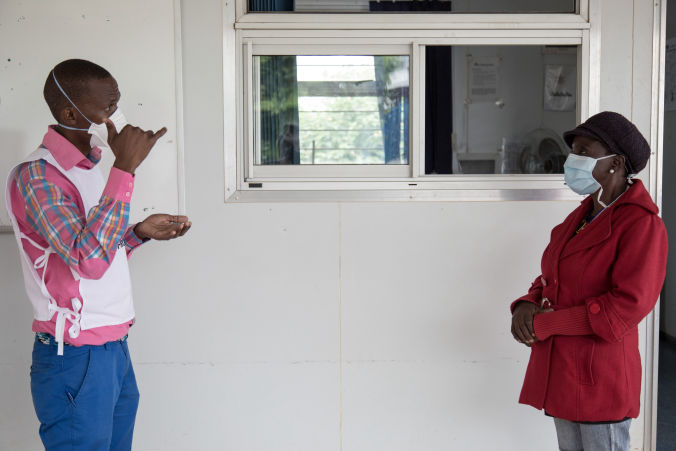 Celumusa Hlatswako (à gauche), conseiller mobile de MSF, parle en langage des signes avec Thulie (à droite), une patiente atteinte de MDR-TB non sourde, lors d'une formation en langage gestuel. Thulie est guérie mais elle voulait apprendre la langue des signes pour aider d'autres patients et d'autres personnes sourdes dans sa communauté. Clinique Matsapha, région de Manzini, Swaziland (Eswatini). Photo : Alexis Huguet.